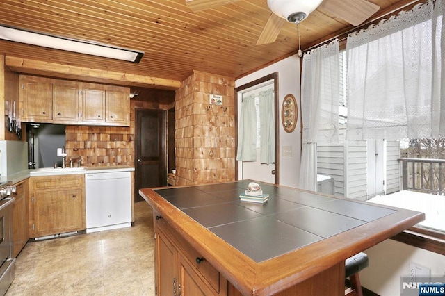 kitchen with tile counters, brown cabinetry, a sink, wooden ceiling, and dishwasher