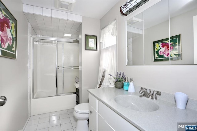 full bath featuring tile patterned flooring, toilet, shower / bath combination with glass door, visible vents, and vanity