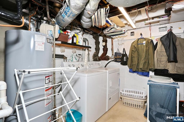 washroom featuring concrete block wall, laundry area, washing machine and clothes dryer, and gas water heater