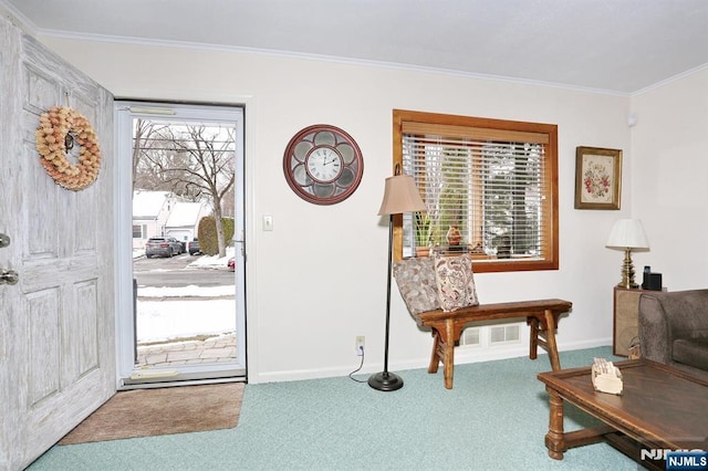 carpeted foyer featuring baseboards and ornamental molding