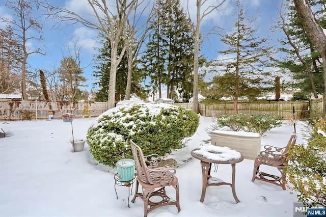 yard covered in snow with a fenced backyard