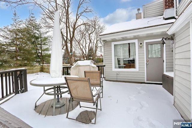 snow covered deck featuring outdoor dining area