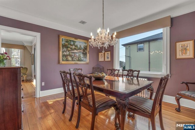 dining space featuring visible vents, light wood-style flooring, crown molding, and baseboards