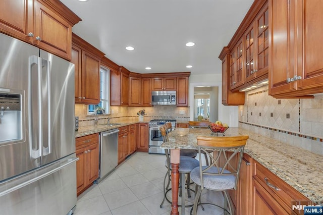 kitchen featuring a sink, appliances with stainless steel finishes, and brown cabinetry