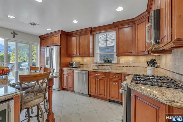 kitchen with brown cabinets, appliances with stainless steel finishes, and a sink