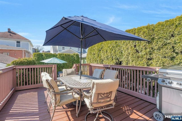 wooden terrace with outdoor dining space and area for grilling