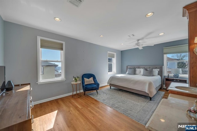 bedroom with recessed lighting, wood finished floors, visible vents, and baseboards