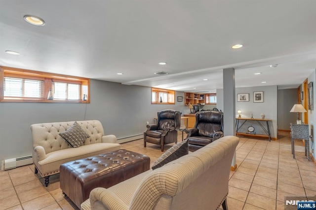 living room with a wealth of natural light, visible vents, and baseboard heating