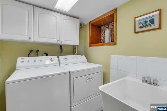 laundry room with separate washer and dryer, cabinet space, and a sink