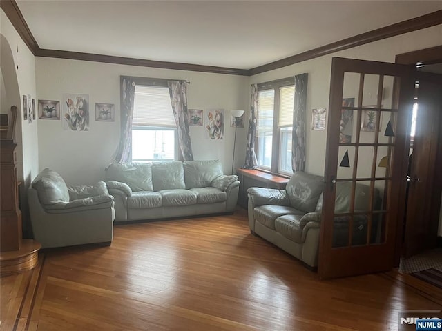 living area with plenty of natural light, ornamental molding, and wood finished floors