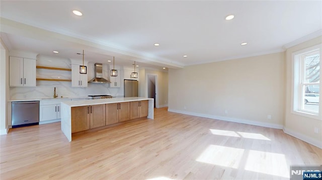 kitchen featuring crown molding, open shelves, stainless steel appliances, a sink, and wall chimney range hood