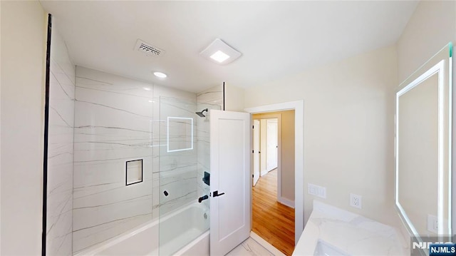 full bathroom featuring shower / bath combination with glass door, baseboards, visible vents, and marble finish floor