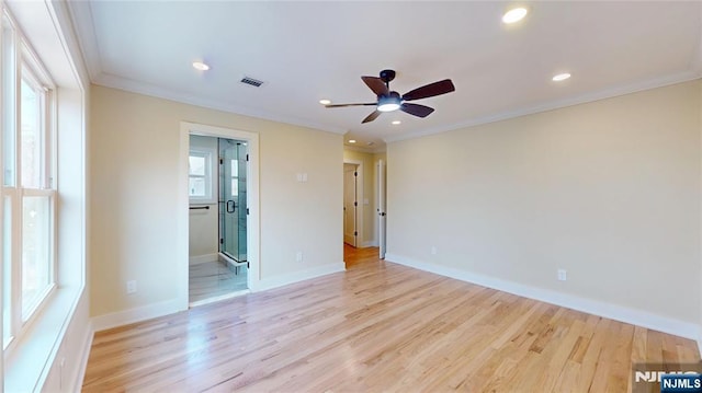 unfurnished room with crown molding, visible vents, and plenty of natural light