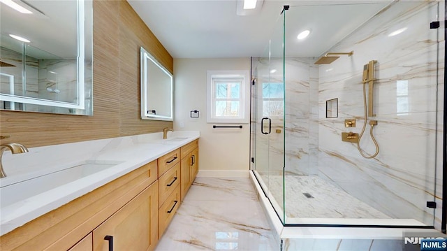 full bath featuring marble finish floor, a sink, a marble finish shower, and double vanity