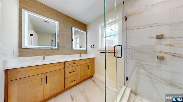 full bathroom featuring marble finish floor, double vanity, a sink, and a marble finish shower