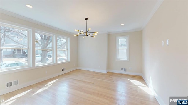 unfurnished dining area with baseboards, visible vents, crown molding, light wood-type flooring, and a notable chandelier