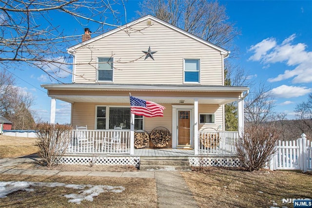 view of front facade with covered porch and fence