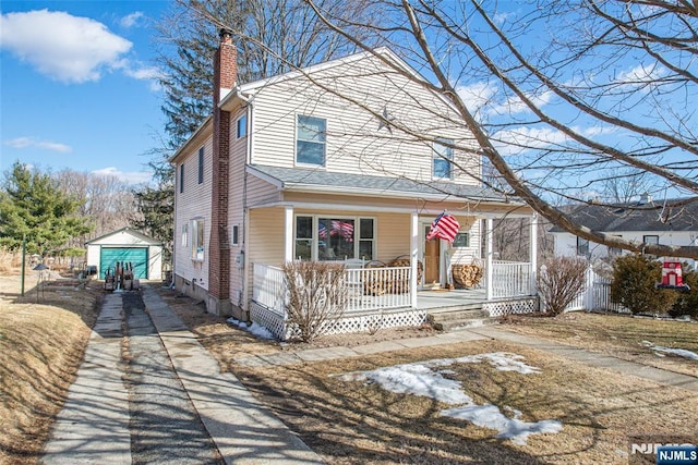 view of front of house featuring an outbuilding, covered porch, driveway, and a chimney