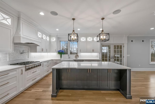 kitchen with light countertops, a center island, white cabinetry, and stainless steel gas stovetop