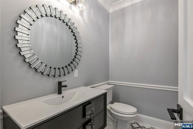 bathroom featuring vanity, toilet, and baseboards