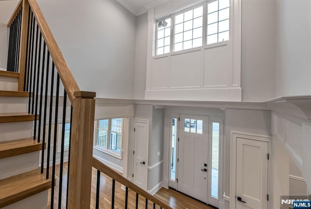 foyer entrance with wood finished floors, baseboards, and stairs