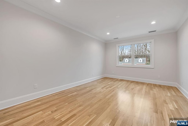 spare room with baseboards, visible vents, ornamental molding, light wood-type flooring, and recessed lighting