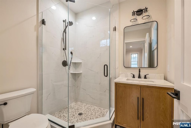 bathroom with a stall shower, vanity, and toilet