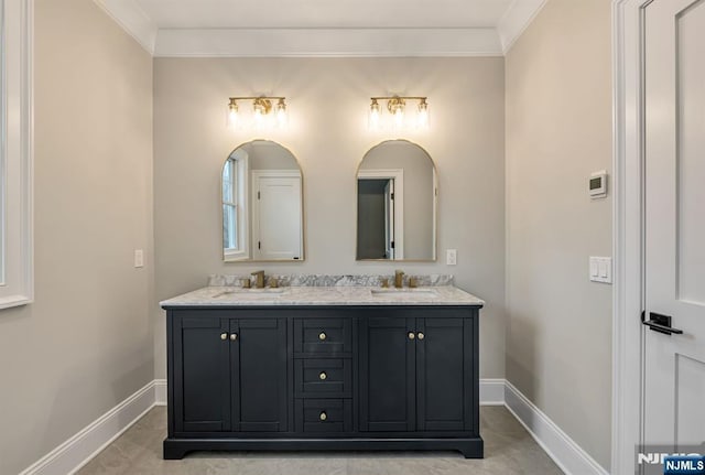 bathroom with double vanity, a sink, and baseboards