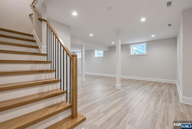 below grade area featuring light wood finished floors, baseboards, visible vents, and recessed lighting