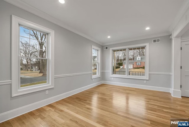 spare room featuring baseboards, visible vents, and crown molding