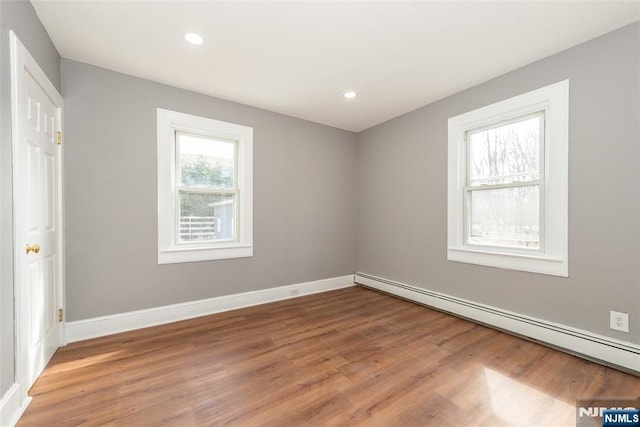 unfurnished room with light wood-type flooring, recessed lighting, baseboards, and baseboard heating