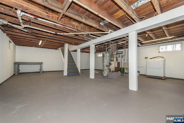 below grade area featuring water heater, independent washer and dryer, and stairs