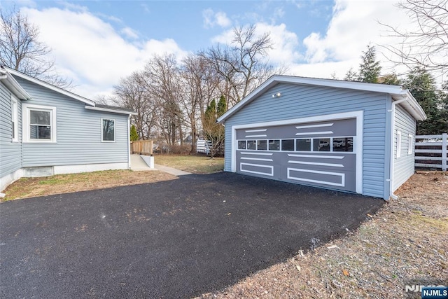 detached garage featuring fence