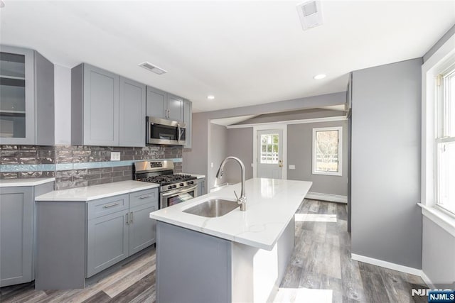 kitchen featuring appliances with stainless steel finishes, visible vents, a sink, and gray cabinetry