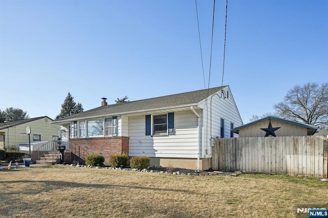 view of front facade with fence, a front lawn, and brick siding