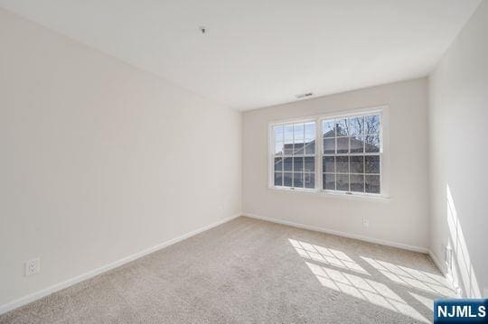 unfurnished room with carpet flooring and baseboards