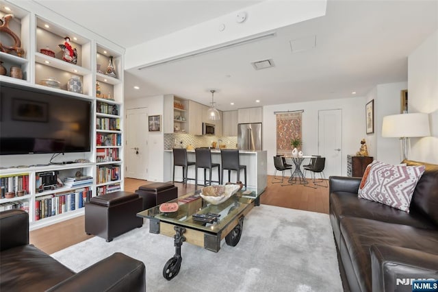 living room featuring recessed lighting, visible vents, and light wood finished floors