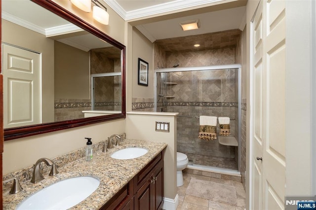 bathroom featuring a stall shower, ornamental molding, and a sink