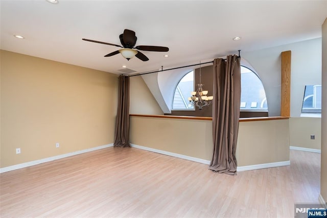 unfurnished room featuring ceiling fan with notable chandelier, recessed lighting, wood finished floors, and baseboards