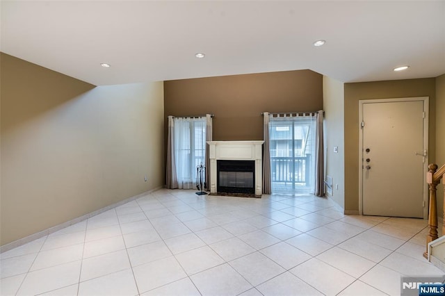 unfurnished living room featuring recessed lighting, baseboards, and a glass covered fireplace