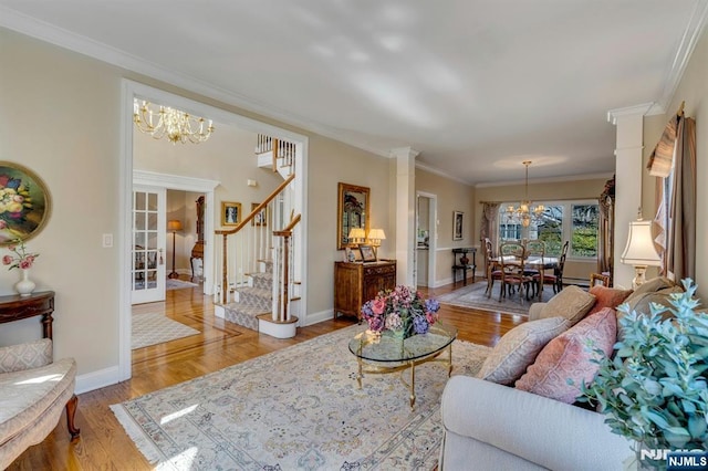 living area featuring a notable chandelier, wood finished floors, crown molding, stairs, and ornate columns