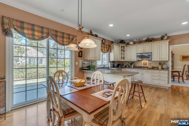 dining area with crown molding, recessed lighting, and light wood-type flooring