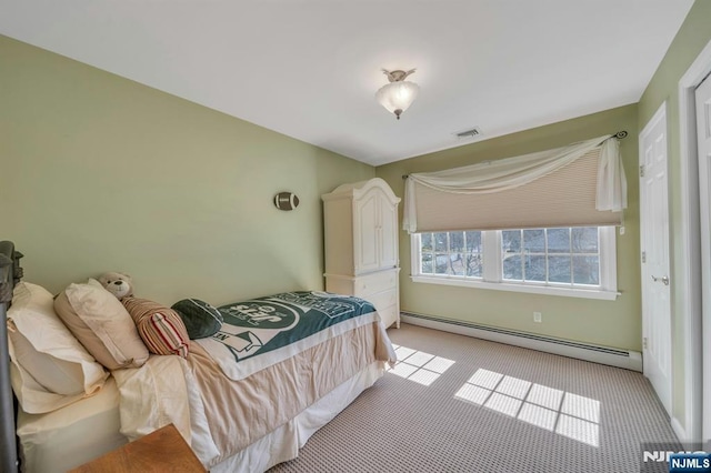 bedroom with a baseboard radiator, light colored carpet, and visible vents