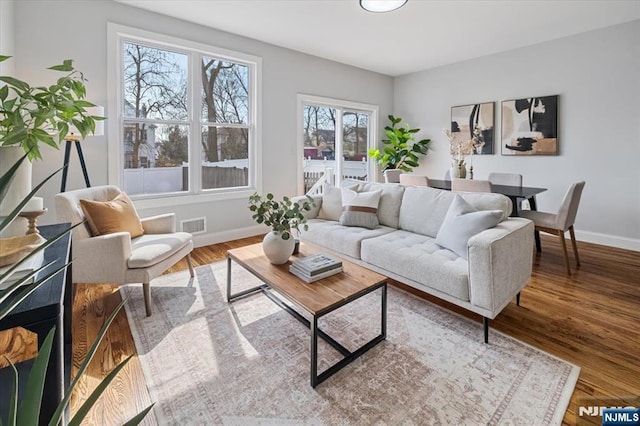 living area featuring wood finished floors, visible vents, and baseboards