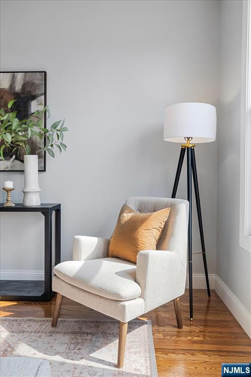 sitting room with baseboards and wood finished floors