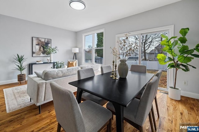 dining area with light wood finished floors, visible vents, and baseboards