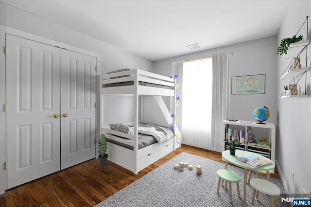 bedroom featuring a closet, wood finished floors, and visible vents