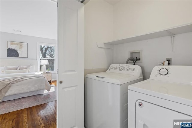 laundry room featuring dark wood-type flooring, laundry area, and washing machine and clothes dryer