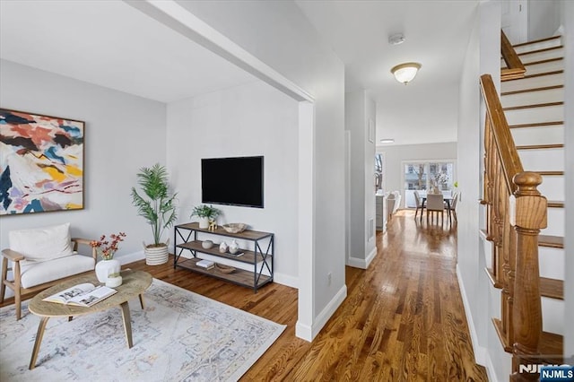 interior space with baseboards, stairway, and wood finished floors