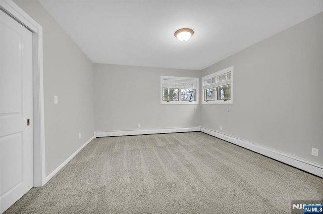 carpeted spare room featuring a baseboard radiator and baseboards